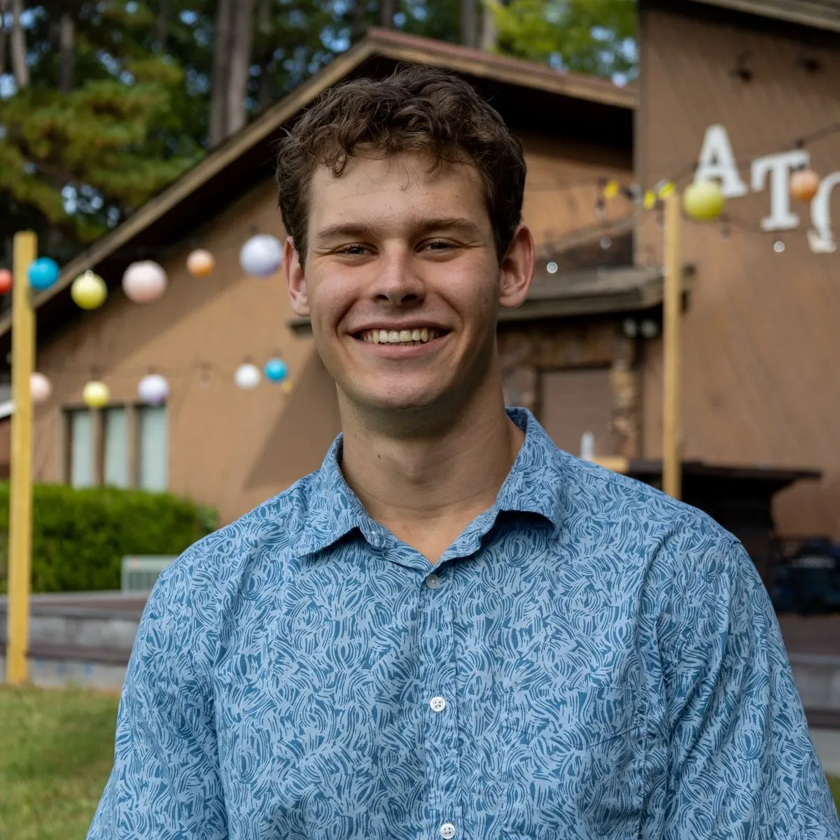 Jonathan Zilkie smiling outdoors at the chapter lodge
